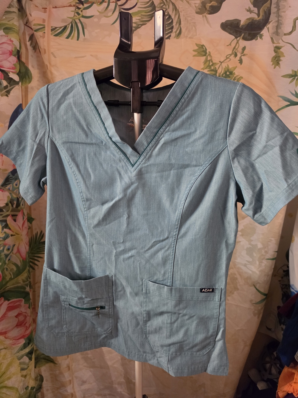 Adar V-neck scrub top featuring short sleeves, front patch pockets, and a zipper